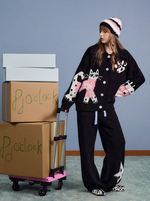Model wearing the black fleece loungewear set with pink and white hat, full body front view