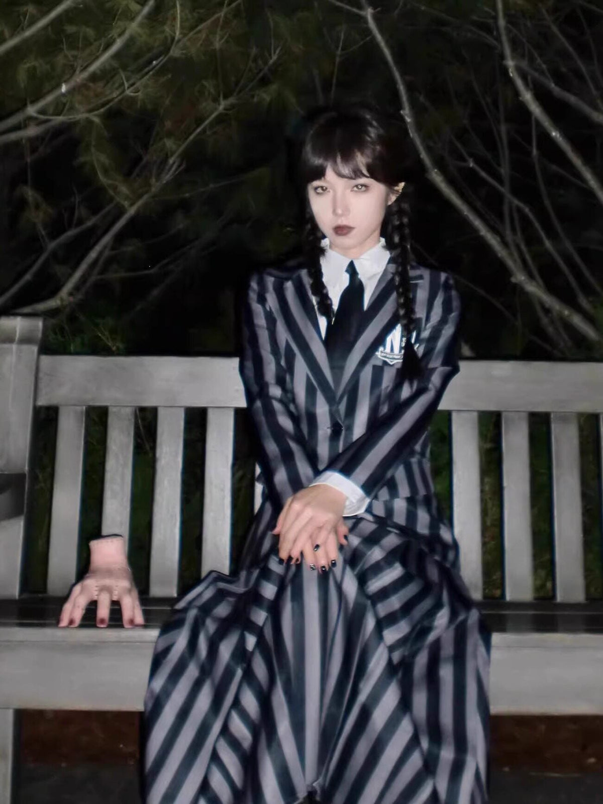 Spot Wednesday Cosy Clothes featuring a black and gray vertical striped dress with a blazer and tie, worn with dark braided hair and gothic makeup.