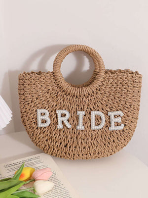 حقيبة straw يدويّة نصف دائرية بلون بني منسوجة بحرف BRIDE مزينة بخواتم دائرية نسائية عصرية وشاطئية