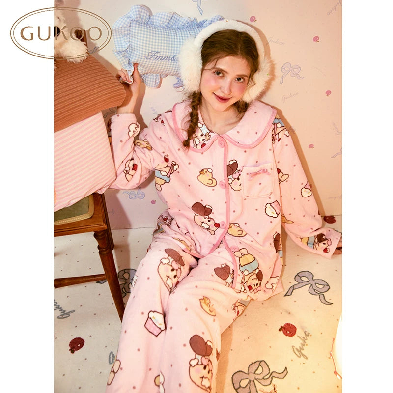 Light pink fleece pajama set with cartoon print, seated front view