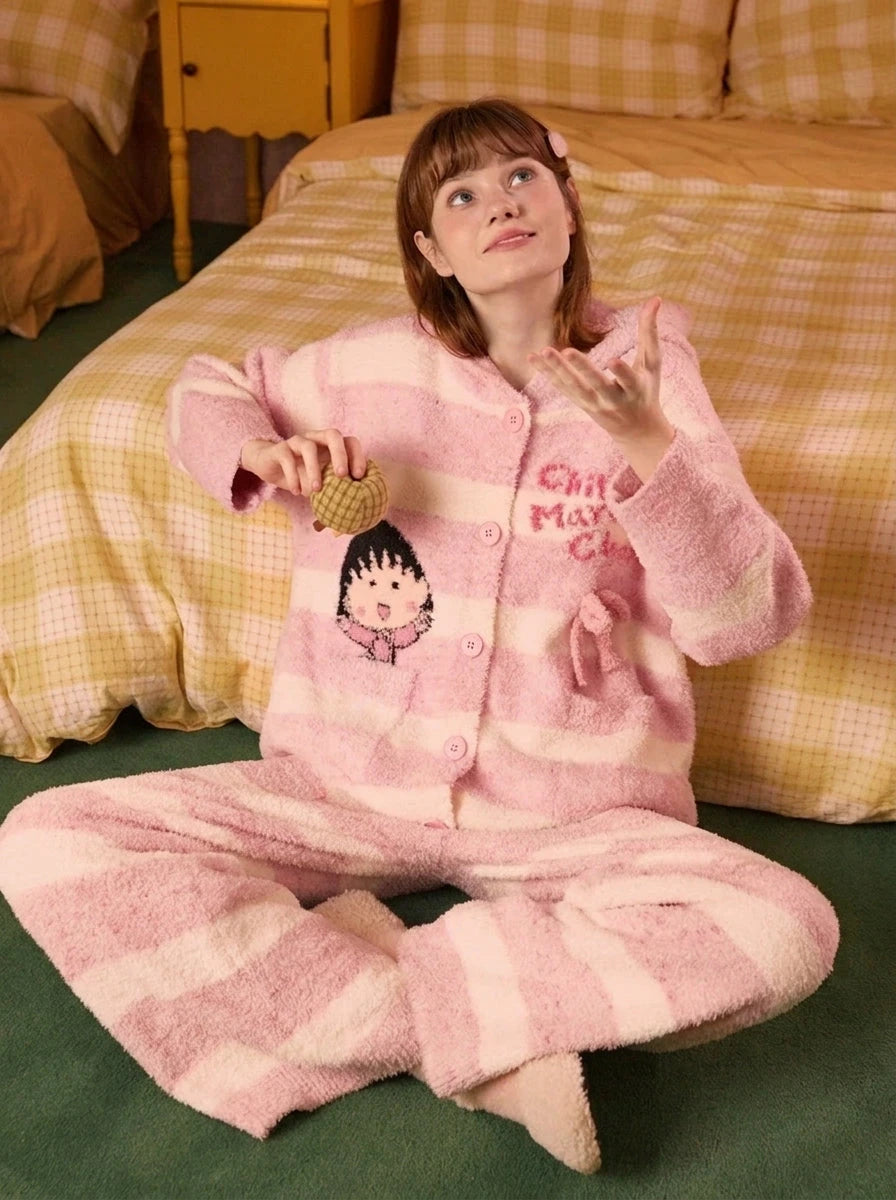 Fleece hooded loungewear set in pink, model sitting on bed