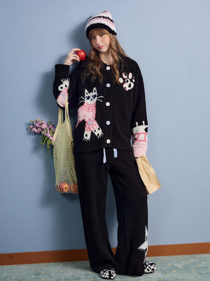 Model wearing the black coral fleece set holding bags, full body front view