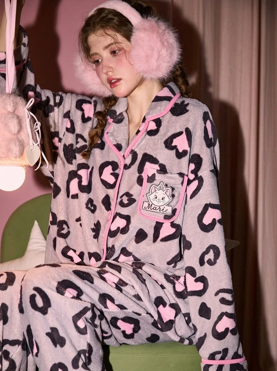 Leopard print pajamas in pink and grey fleece, model seated front view