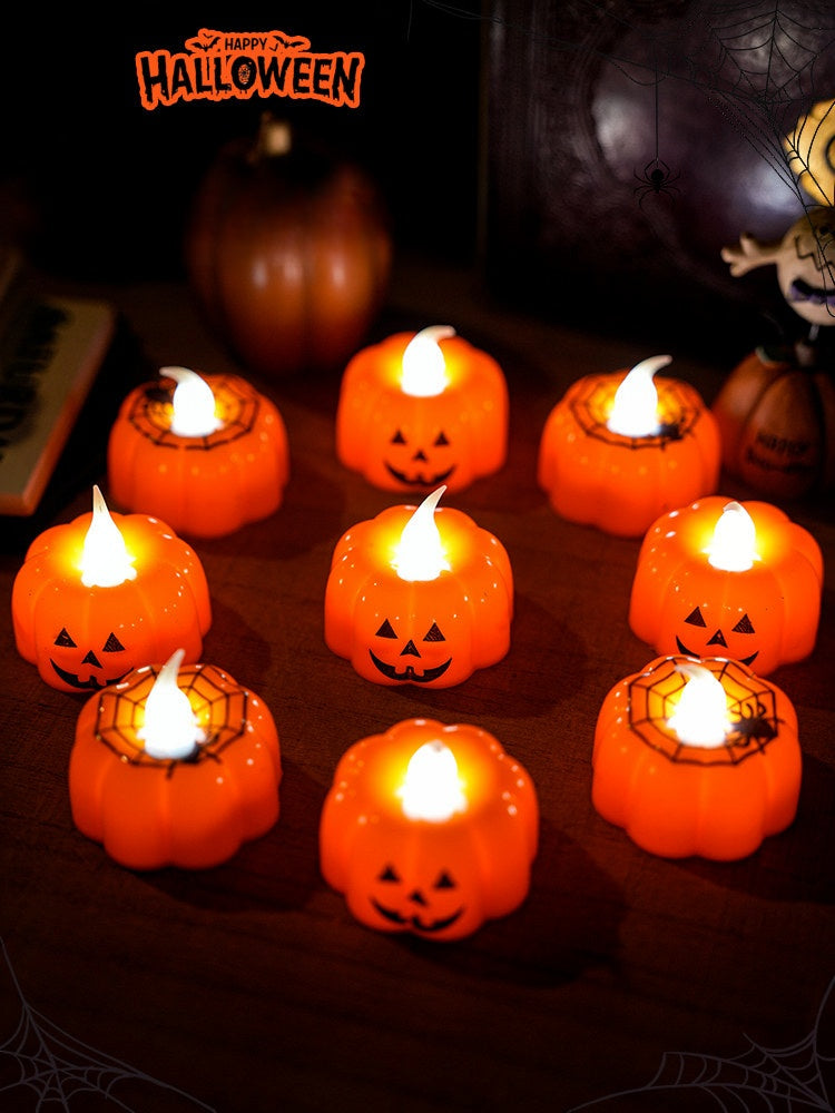 Jack-o'-lantern shaped orange glowing candles with smiling faces and spider web patterns as Halloween table ornaments.